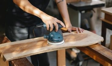 KB Construction employee sanding down wood