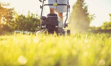 KB Construction employee mowing client lawn